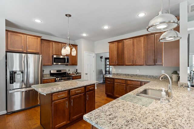 kitchen featuring decorative light fixtures, sink, dark hardwood / wood-style floors, and appliances with stainless steel finishes