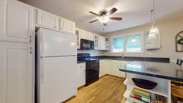 kitchen featuring kitchen peninsula, white cabinetry, sink, and black appliances