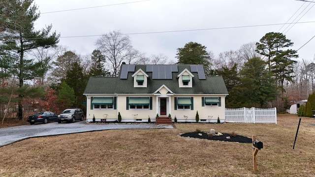 cape cod-style house with solar panels and a front lawn