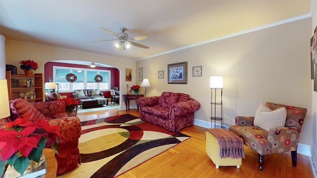 living room with ceiling fan and ornamental molding