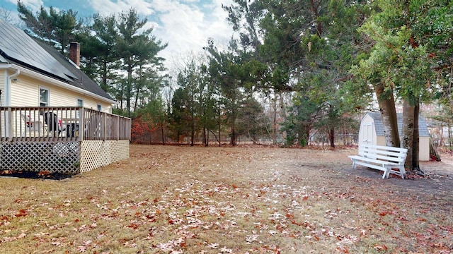 view of yard featuring a storage unit and a deck