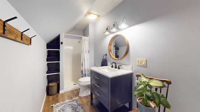 bathroom featuring vanity, lofted ceiling, hardwood / wood-style flooring, a shower with shower curtain, and toilet