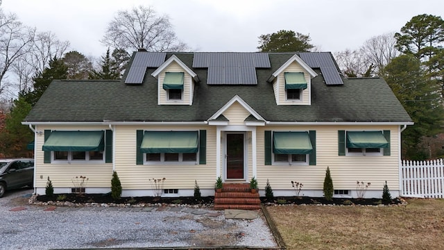 new england style home featuring solar panels