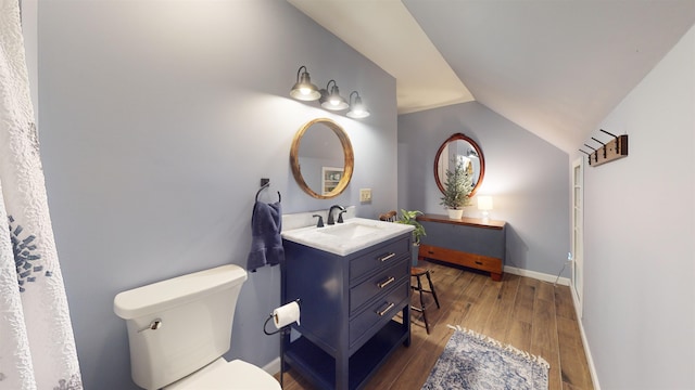 bathroom with hardwood / wood-style floors, vanity, lofted ceiling, and toilet