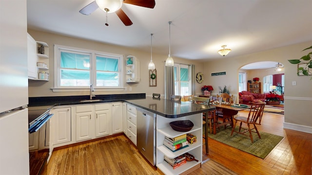 kitchen featuring white cabinetry, dishwasher, sink, kitchen peninsula, and light wood-type flooring