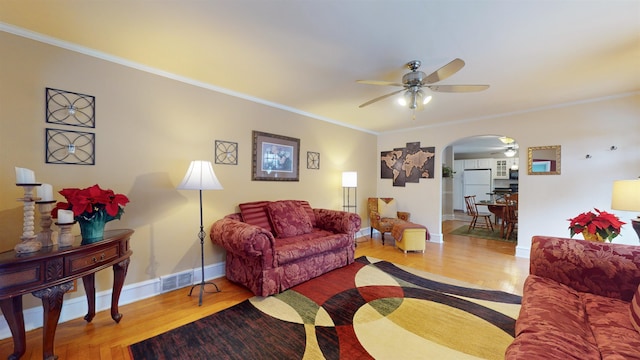 living room featuring ceiling fan, light wood-type flooring, and ornamental molding