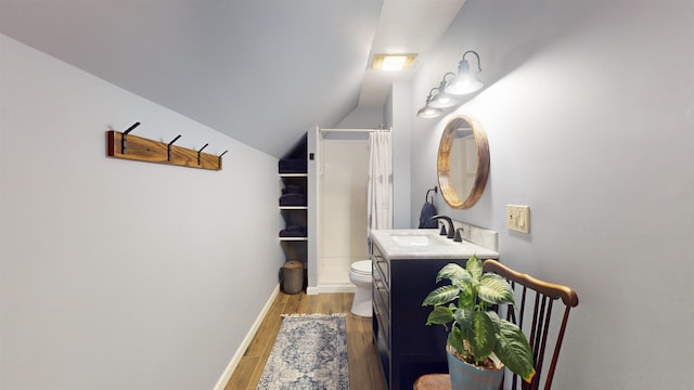 bathroom featuring vanity, vaulted ceiling, hardwood / wood-style flooring, a shower with shower curtain, and toilet