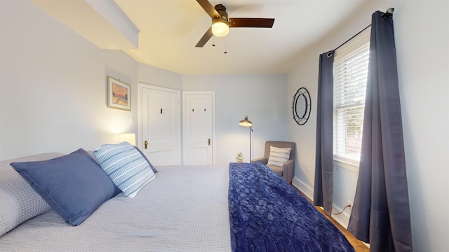 bedroom with ceiling fan and multiple windows