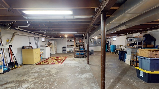 basement featuring white fridge and washing machine and clothes dryer