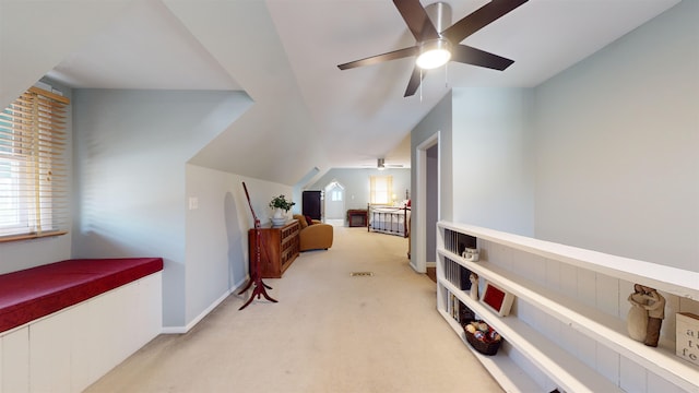 interior space featuring ceiling fan, light colored carpet, and vaulted ceiling