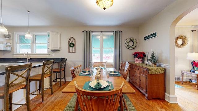 dining area featuring light wood-type flooring and sink