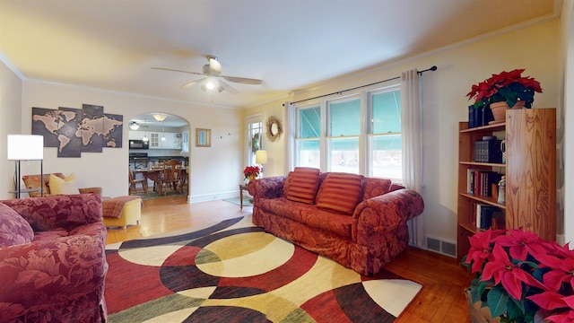 living room featuring hardwood / wood-style flooring, ceiling fan, and ornamental molding