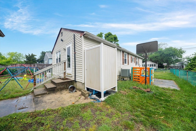 view of side of property featuring a shed, central AC unit, and a yard