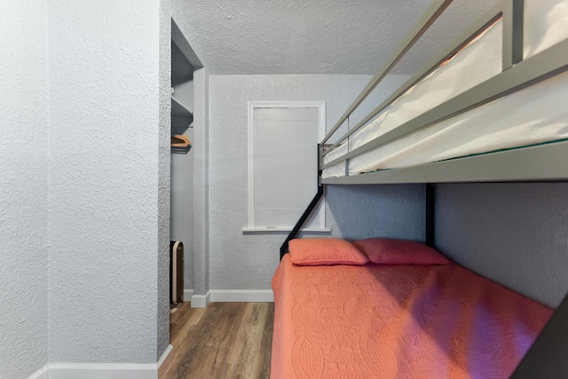 bedroom with dark wood-type flooring and a textured ceiling