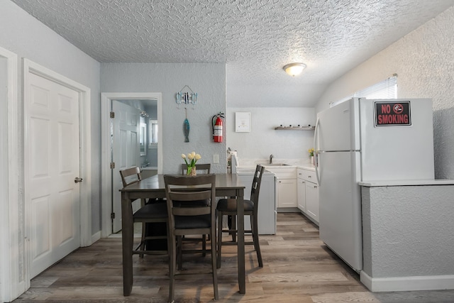 dining room with hardwood / wood-style flooring and a textured ceiling