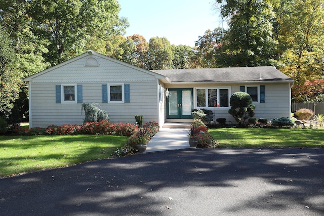 ranch-style house with a front lawn and french doors