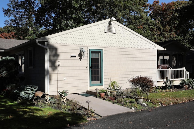 view of side of home featuring covered porch