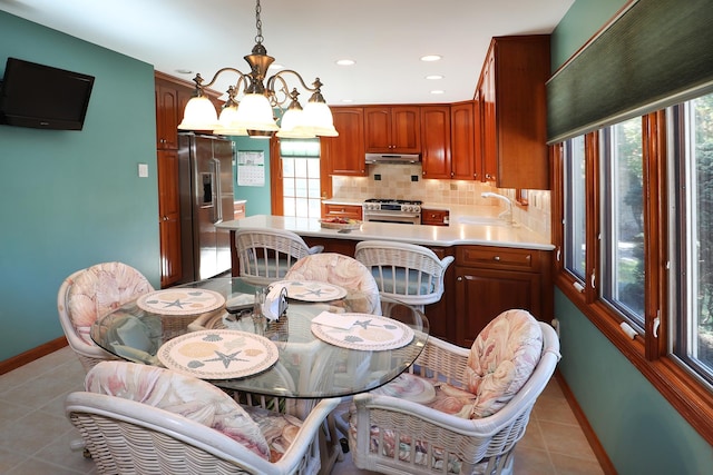 tiled dining area featuring a notable chandelier and sink