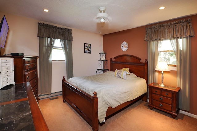 carpeted bedroom with a baseboard radiator and ceiling fan