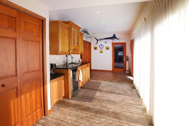kitchen featuring stainless steel dishwasher, decorative backsplash, and sink