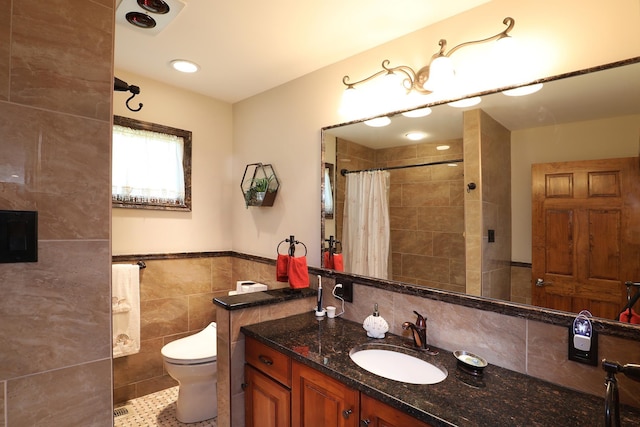 bathroom with vanity, tile patterned flooring, toilet, tile walls, and curtained shower
