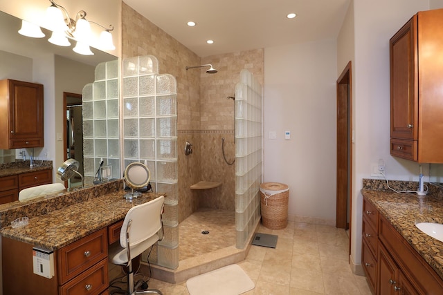 bathroom featuring tile patterned flooring, vanity, and tiled shower