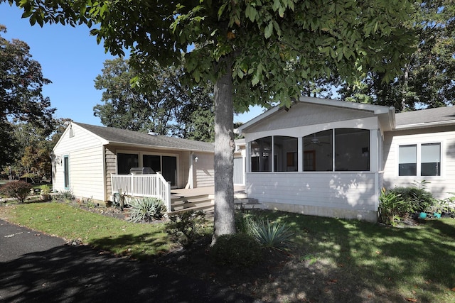 view of front of house with a sunroom, a front lawn, and a porch