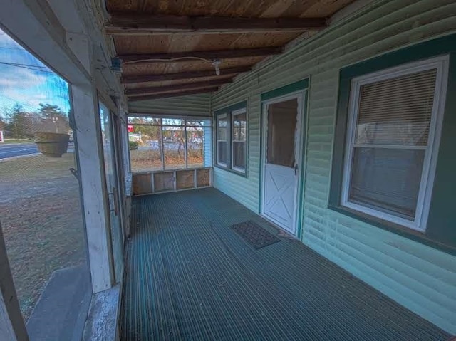 unfurnished sunroom with vaulted ceiling with beams and wood ceiling