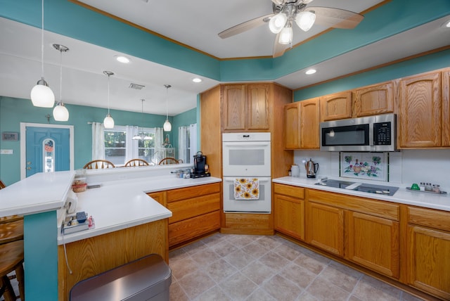 kitchen with ceiling fan, hanging light fixtures, white appliances, a breakfast bar area, and decorative backsplash