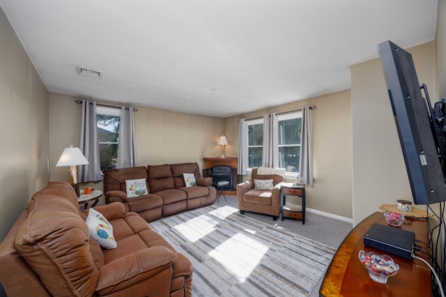 living room with carpet flooring, a fireplace, and a wealth of natural light