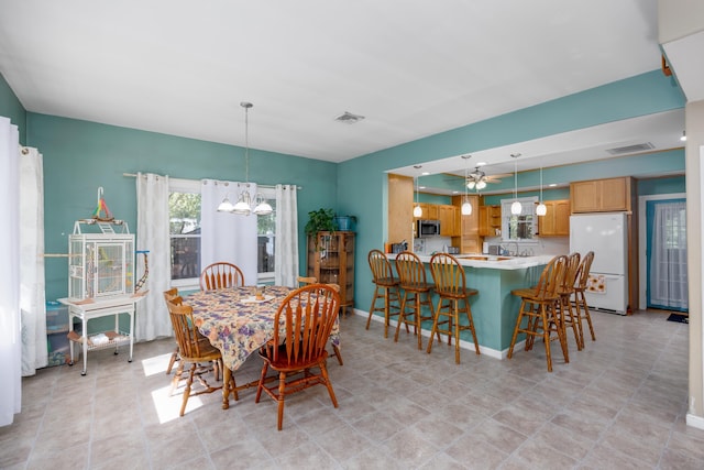 dining room featuring ceiling fan with notable chandelier