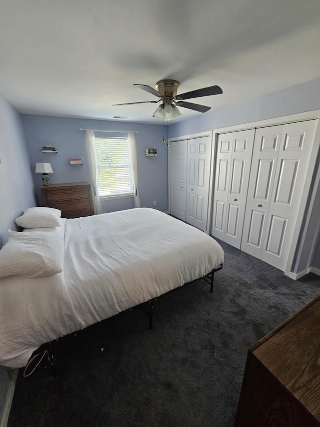 carpeted bedroom with multiple closets and ceiling fan