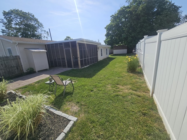 view of yard featuring a fenced backyard and a sunroom