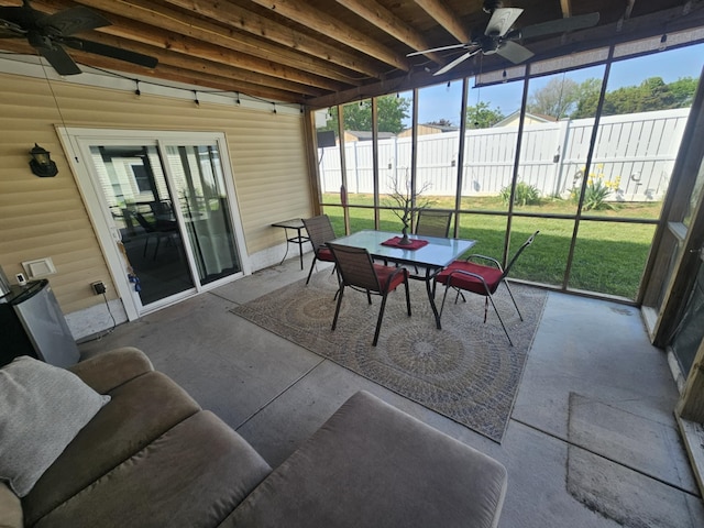 sunroom featuring a ceiling fan and outdoor dining space