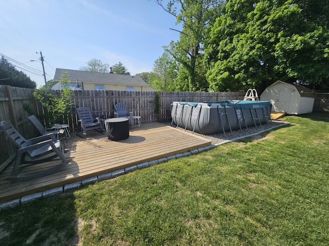 view of yard with a storage shed, a wooden deck, a fenced backyard, a fenced in pool, and an outdoor structure