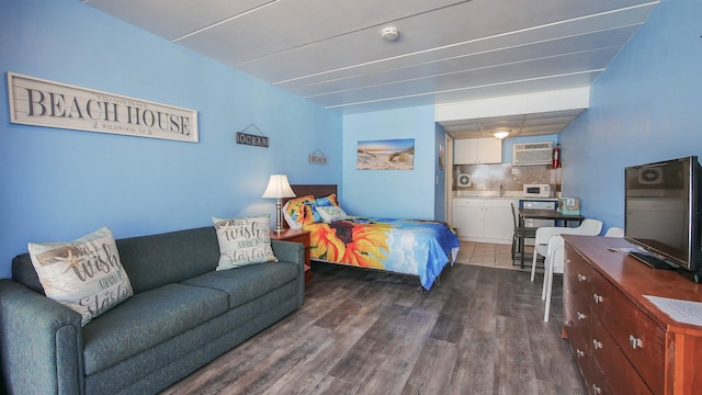 bedroom featuring a wall mounted AC and dark wood-style flooring