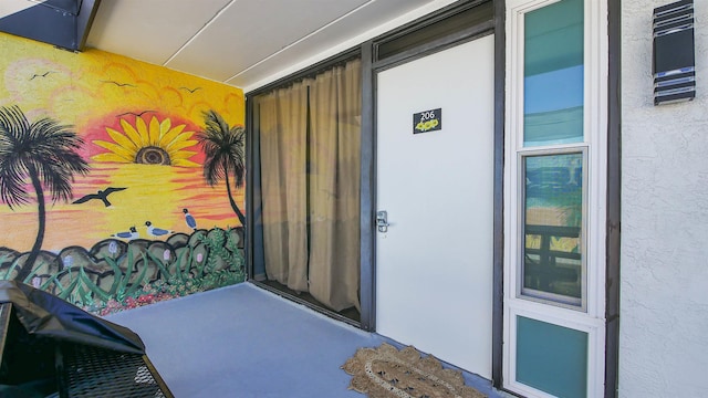 doorway to property featuring stucco siding