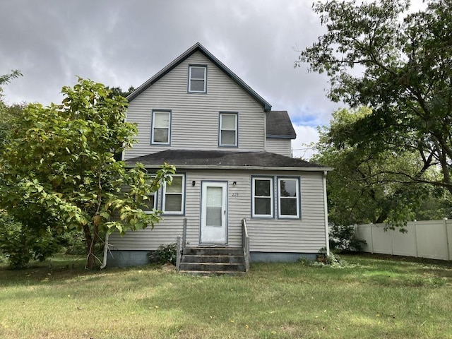 rear view of house featuring a lawn