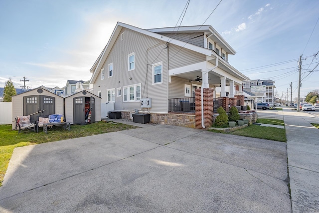 220 E 21st Ave, North Wildwood, NJ 08260 - view of home's exterior with an outdoor structure, a storage unit, a ceiling fan, a porch, and a lawn