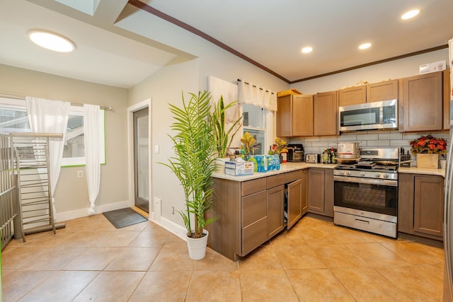 220 E 21st Ave, North Wildwood, NJ 08260 - kitchen featuring light countertops, tasteful backsplash, appliances with stainless steel finishes, light tile patterned floors, and ornamental molding