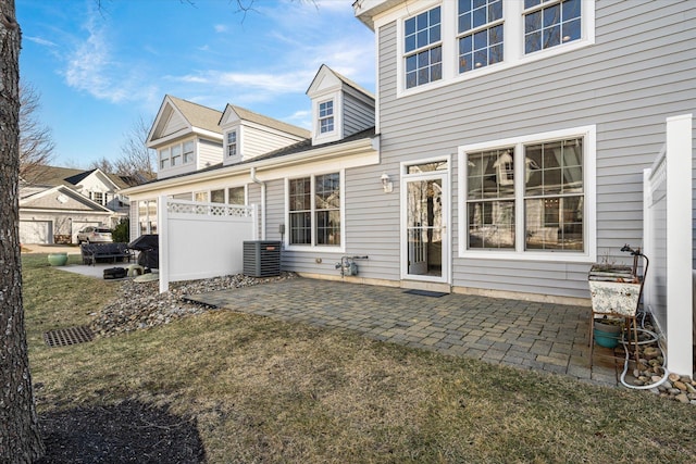 rear view of property with central AC, a yard, and a patio