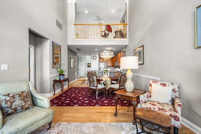 interior space featuring a high ceiling, ceiling fan, and light hardwood / wood-style flooring