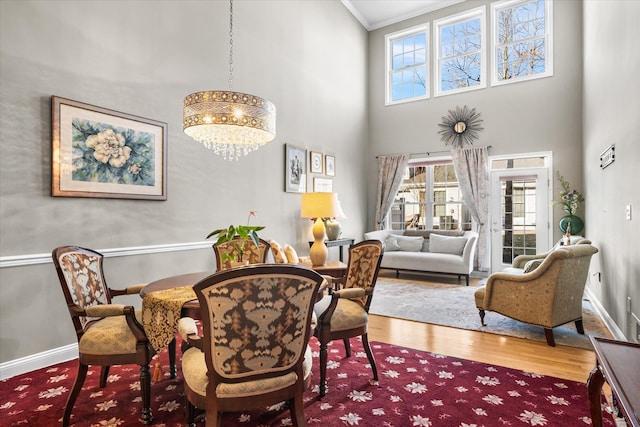 dining room with hardwood / wood-style flooring, ornamental molding, plenty of natural light, and an inviting chandelier