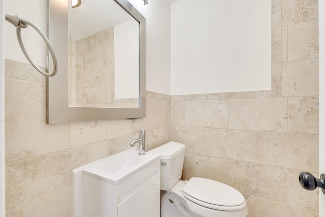 bathroom featuring tile walls, vanity, and toilet