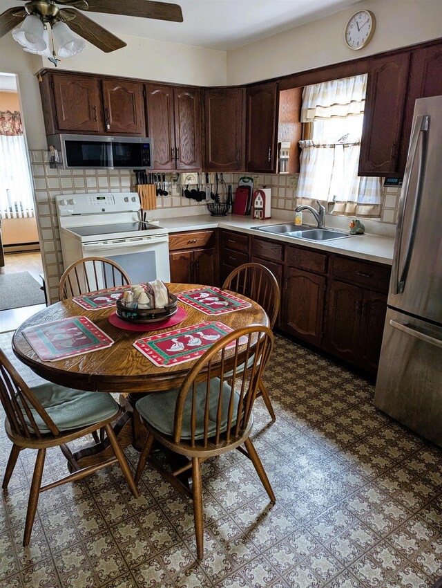 kitchen featuring dark brown cabinetry, white range with electric cooktop, sink, stainless steel fridge, and ceiling fan