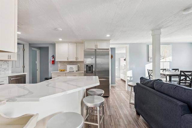 140 E Burk Ave Unit A, Wildwood, NJ 08260 - kitchen with appliances with stainless steel finishes, light wood finished floors, tasteful backsplash, a kitchen breakfast bar, and recessed lighting