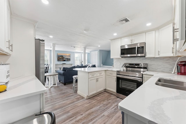 140 E Burk Ave Unit A, Wildwood, NJ 08260 - kitchen featuring appliances with stainless steel finishes, open floor plan, a peninsula, light wood-type flooring, and white cabinets