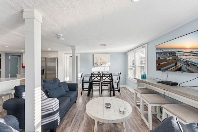 140 E Burk Ave Unit A, Wildwood, NJ 08260 - living room with decorative columns, light wood-style flooring, a textured ceiling, and recessed lighting