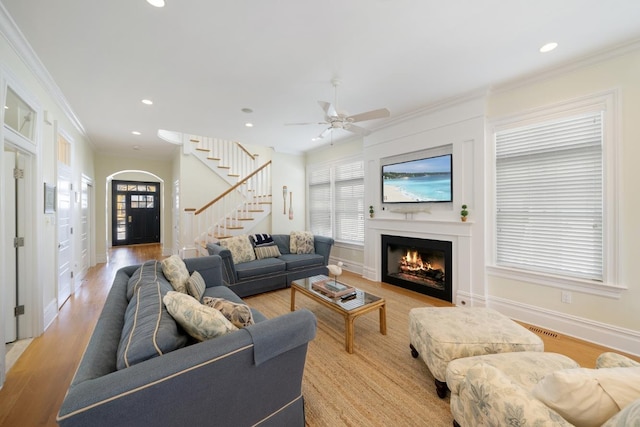 261 45th St, Avalon, NJ 08202 - living area featuring a warm lit fireplace, stairs, healthy amount of natural light, ornamental molding, and light wood finished floors