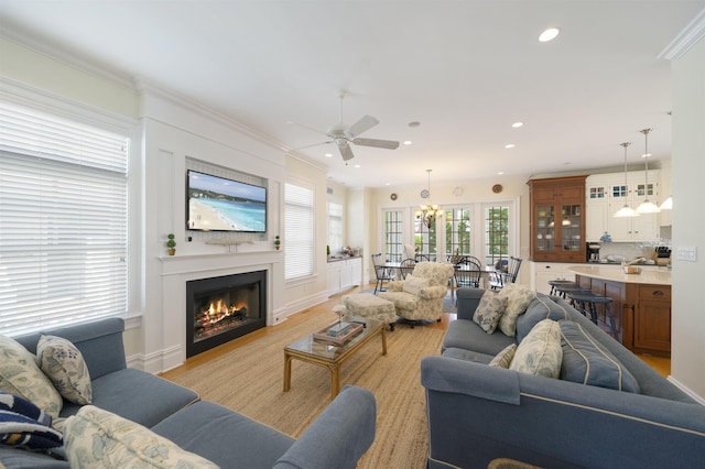 261 45th St, Avalon, NJ 08202 - living area featuring ceiling fan, a warm lit fireplace, ornamental molding, recessed lighting, and a chandelier
